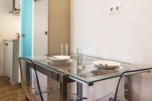 a glass table with plates and glasses on it at Syntagma Gem 2 in Athens