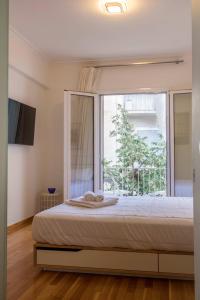 a bedroom with a large bed and a window at Syntagma Gem 2 in Athens
