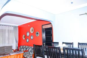 a dining room with red walls and black chairs at Larry Homestay in Kapchorwa +5 photos
