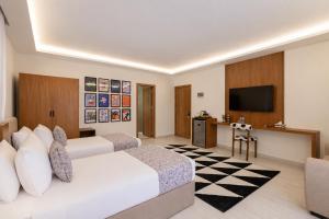 a hotel room with two beds and a flat screen tv at Seven Stays Centric West Zayed in Sheikh Zayed