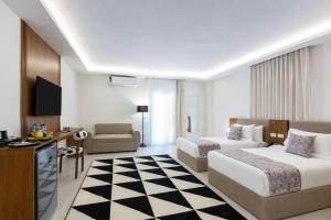a hotel room with two beds and a television at Seven Stays Centric West Zayed in Sheikh Zayed +139 photos