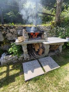 a stone table with a fire pit in a yard at Casa Panorama Intelvi - Como & Lugano Lakes in Laino