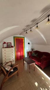 a living room with a red couch and a table at Longo maï in Vallon-Pont-dʼArc