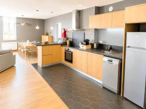 a kitchen with wooden cabinets and a dining room at Aux loges du théâtre in Moulins