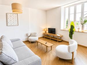 a living room with a couch and a tv at Aux loges du théâtre in Moulins