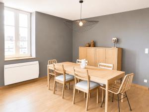 a dining room with a wooden table and chairs at Aux loges du théâtre in Moulins +4 photos