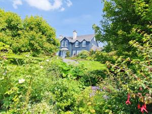 a blue house in the middle of a garden at Apartments at Ballinsheen House & Gardens in Lisdoonvarna