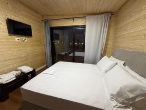 a bedroom with a large white bed and a window at Paradise Beachfront Chalet Rooms Borsh in Borsh +28 photos