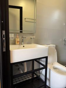 a bathroom with a white sink and a toilet at Paradise Beachfront Chalet Rooms Borsh in Borsh