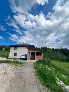 a house with a car parked in front of it at Albanica Guesthouse in Dacići