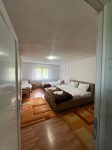 a bedroom with a bed and a living room at Albanica Guesthouse in Dacići
