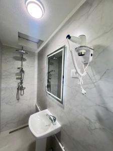 a bathroom with a sink and a hair dryer on the wall at Albanica Guesthouse in Dacići