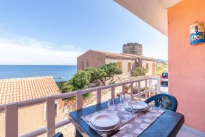 a table on a balcony with a view of the ocean at Vista Corsica in Isola Rossa