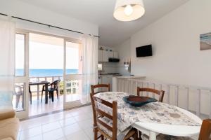 a kitchen and dining room with a table and a balcony at Vista Corsica in Isola Rossa