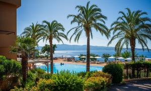 a view of a resort with palm trees and a swimming pool at Altafiumara Resort & Spa in Villa San Giovanni
