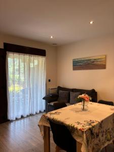 a living room with a table and a couch at Apartamentos Fuente La Pipa in Avín +10 photos