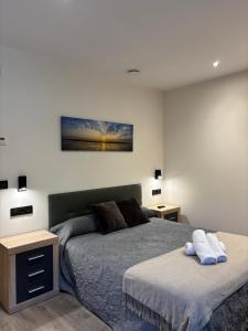a bedroom with two beds and a painting on the wall at Apartamentos Fuente La Pipa in Avín