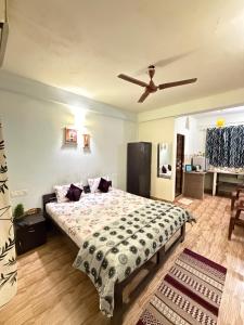a bedroom with a bed and a ceiling fan at spectrum hub beach side apartment in Candolim