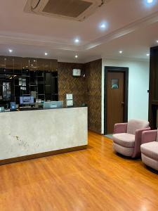 a lobby with a reception desk and two chairs at ELYSIUM Premier Suites Hitec City in Hyderabad