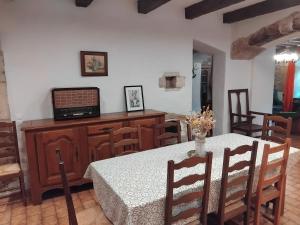 a dining room with a table and chairs and a television at gite La Tour Au Comté in Charency
