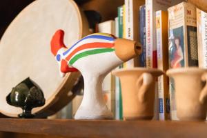 a wooden duck figurine on a shelf with books at Giardino Frannicola in Maglie