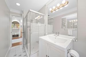 a white bathroom with a shower and a sink at Royalty B&B in Richmond +19 photos