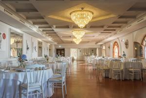 a banquet hall with white tables and chairs at Altafiumara Resort & Spa in Villa San Giovanni