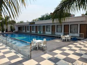 a swimming pool with tables and chairs next to a building at The Kashi Dharohar in Varanasi
