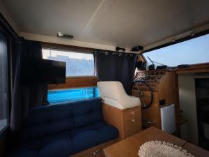 a living room with a couch and a tv in an rv at Nuit insolite dans un bateau in Le Havre +3 photos