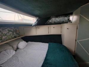 a small bed in the back of a room at Nuit insolite dans un bateau in Le Havre
