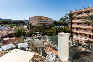 a view of a balcony with palm trees and buildings at Hotel Playas de Paguera in Paguera
