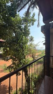 a balcony of a house with a tree at spectrum hub beach side apartment in Candolim