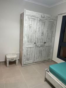 a large wooden door in a room with a bed at Chalet in north coast in El Dab‘a +1 photo
