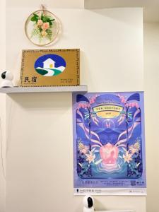 a shelf with a poster and a picture of a uterus at 回巢 歸宿 Hui Chao Gui Su 民宿編號2121號 in Taitung City