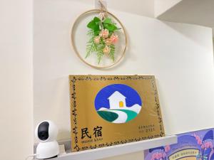 a sign on a shelf with a clock on the wall at 回巢 歸宿 Hui Chao Gui Su 民宿編號2121號 in Taitung City