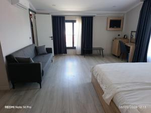 a bedroom with a bed and a couch and a table at Green Side Leon Hotel in Side