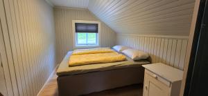 ein Bett in einem kleinen Zimmer mit Fenster in der Unterkunft Stølsheim in Tyinkrysset