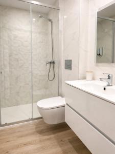 a bathroom with a toilet and a sink and a shower at Casa Candil in Nazaré
