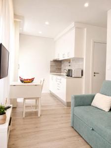 a living room with a blue couch and a kitchen at Casa Candil in Nazaré