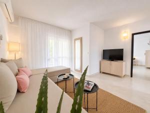 a white living room with a couch and a tv at Waterman Svpetrvs Resort - All Inclusive in Supetar