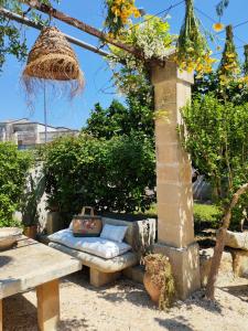a bench with a pillow on it next to a table at Giardino Frannicola in Maglie