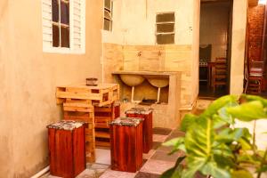 a room with three wooden stools and a fireplace at Pousada 3 Bruxas Casa de Hóspedes in São Thomé das Letras