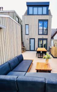 a blue couch sitting on a deck with a table at Bella's Place in Breda