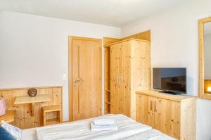 a bedroom with a bed and a flat screen tv at Appartements Spitaler in Ried im Zillertal