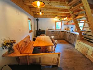 a large kitchen with a wooden table in a cabin at Gorsko zavetje Cottage in Soča
