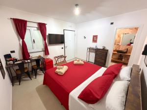 a bedroom with a red bed and a dining room at VaSaMi - Appartamento in centro in Bari