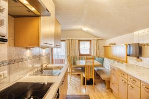 a kitchen with a sink and a table in it at Appartements Spitaler in Ried im Zillertal