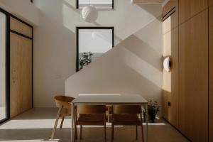 a dining room with a white table and chairs at The Habitus Residence, a Design house in Corfu