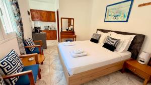a bedroom with a bed and a kitchen at Avlakia Sunrise Haven Studios in Avlákia +34 photos
