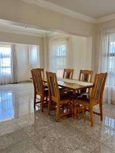 a dining room with a wooden table and chairs at Kairos Guest House in Maseru